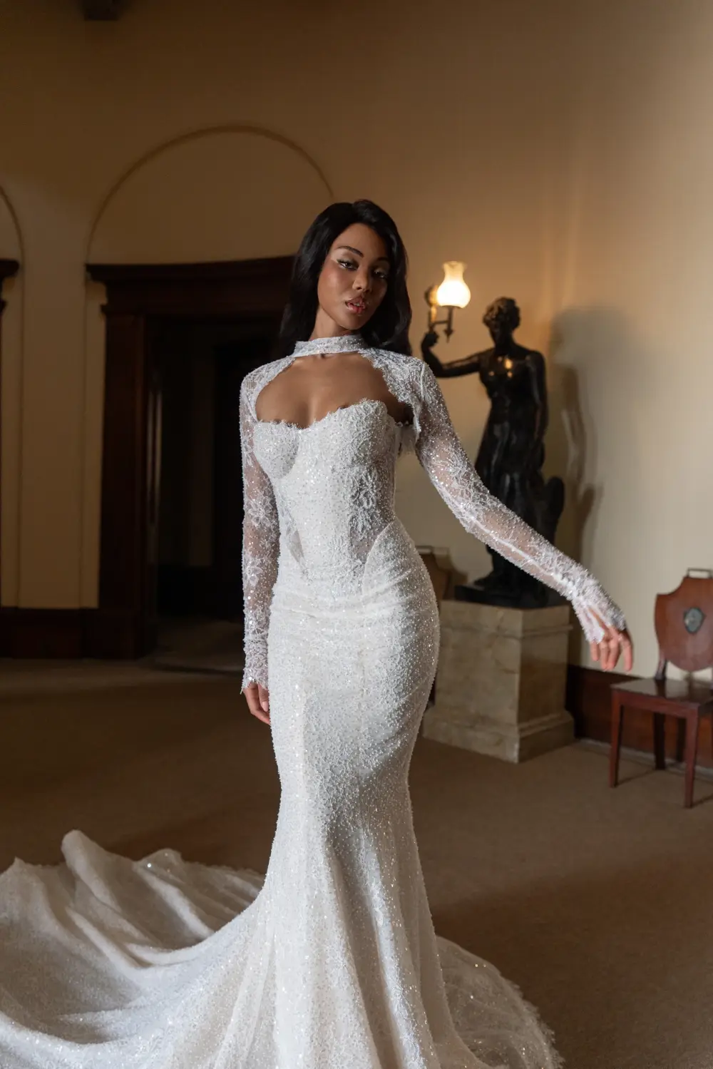 model is wearing a lace bridal gown with a long sleeve bolero