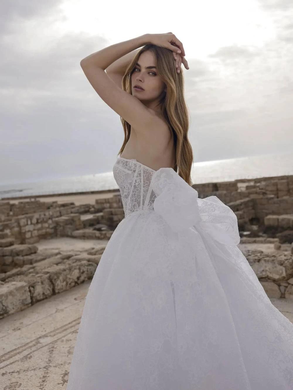 Model wearing a white dress by Pnina Tornai