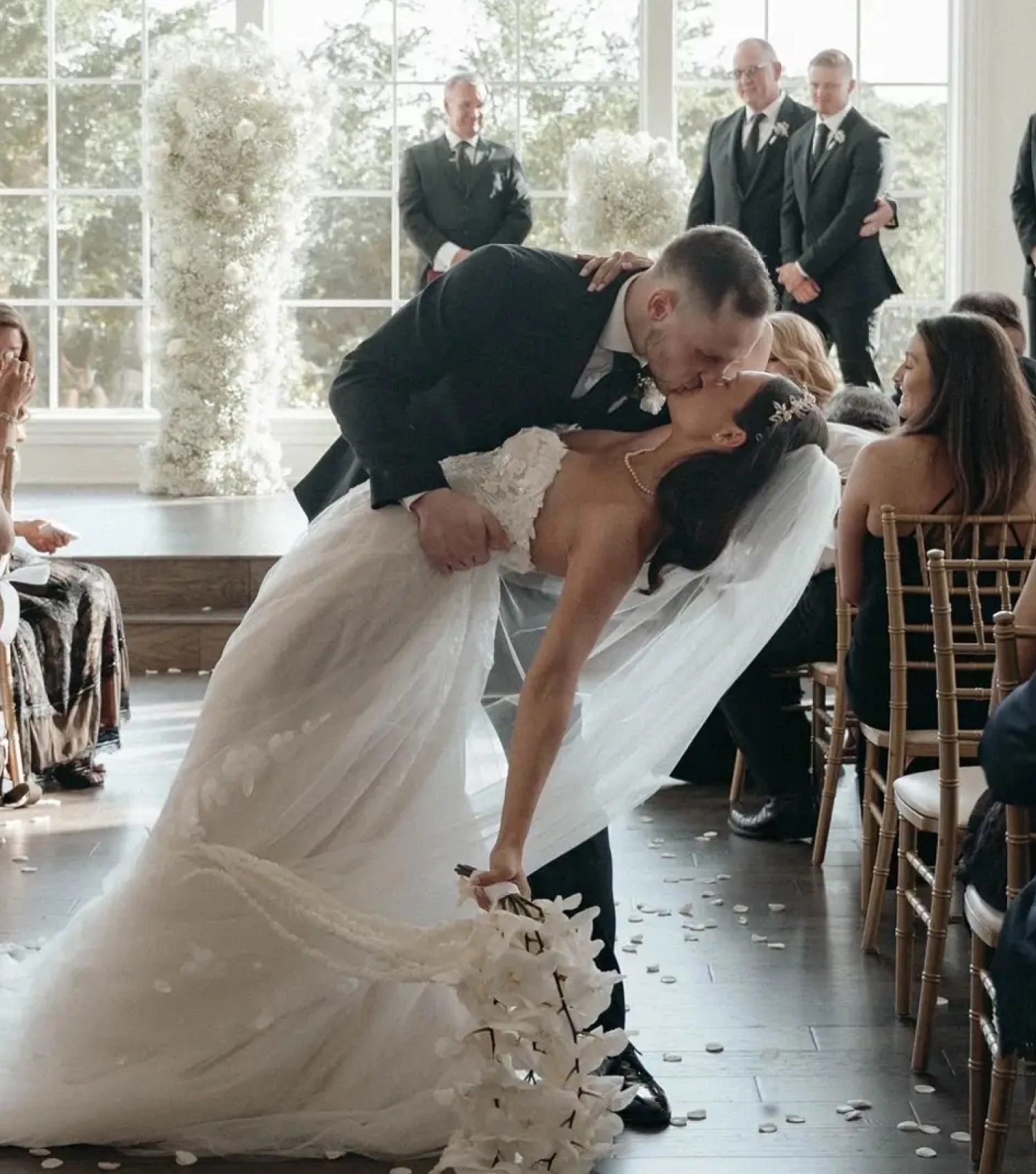 Сouple wearing a white gown and a black suit. Mobile image