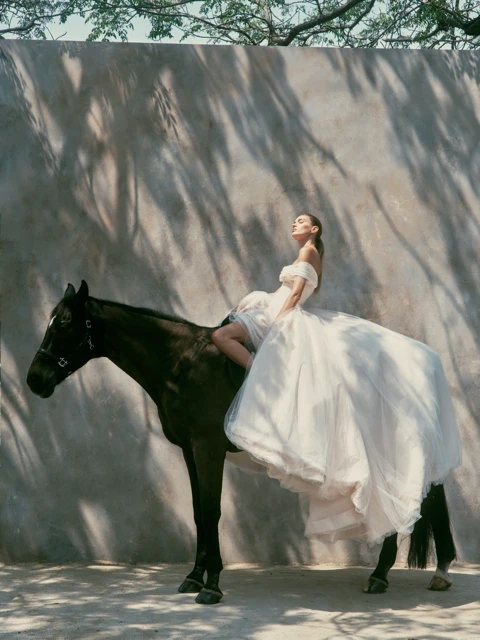 Model wearing a white dress by Nicole and Felicia