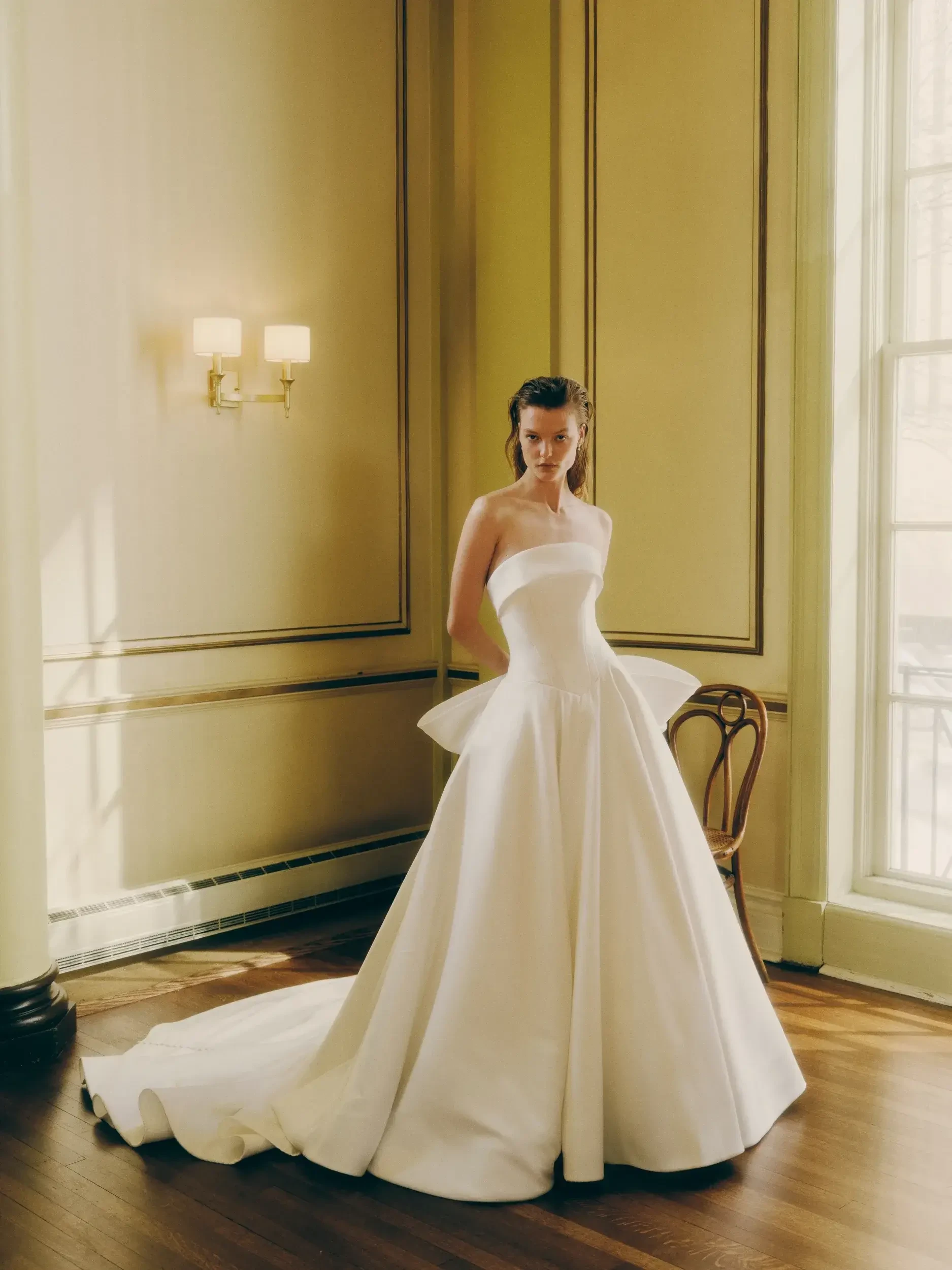 model is wearing a strapless satin ball gown wedding dress