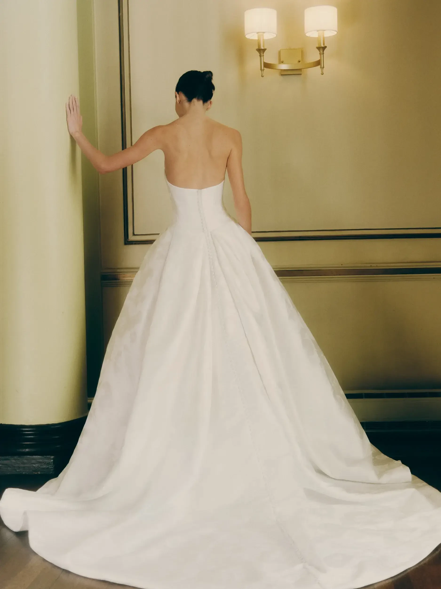 model is wearing a strapless ball gown wedding gown