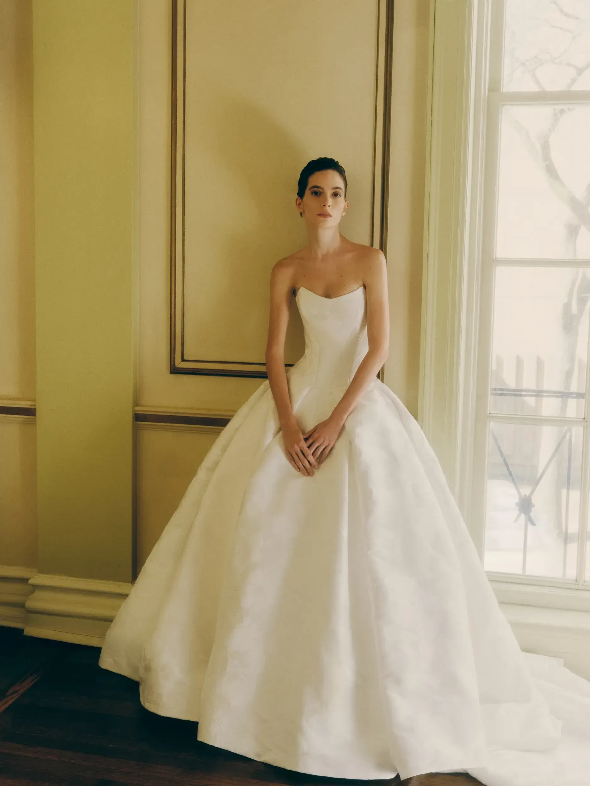 model is wearing a strapless ball gown wedding gown